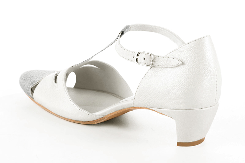 Light silver and pure white women's T-strap open side shoes. Round toe. Low comma heels. Rear view - Florence KOOIJMAN